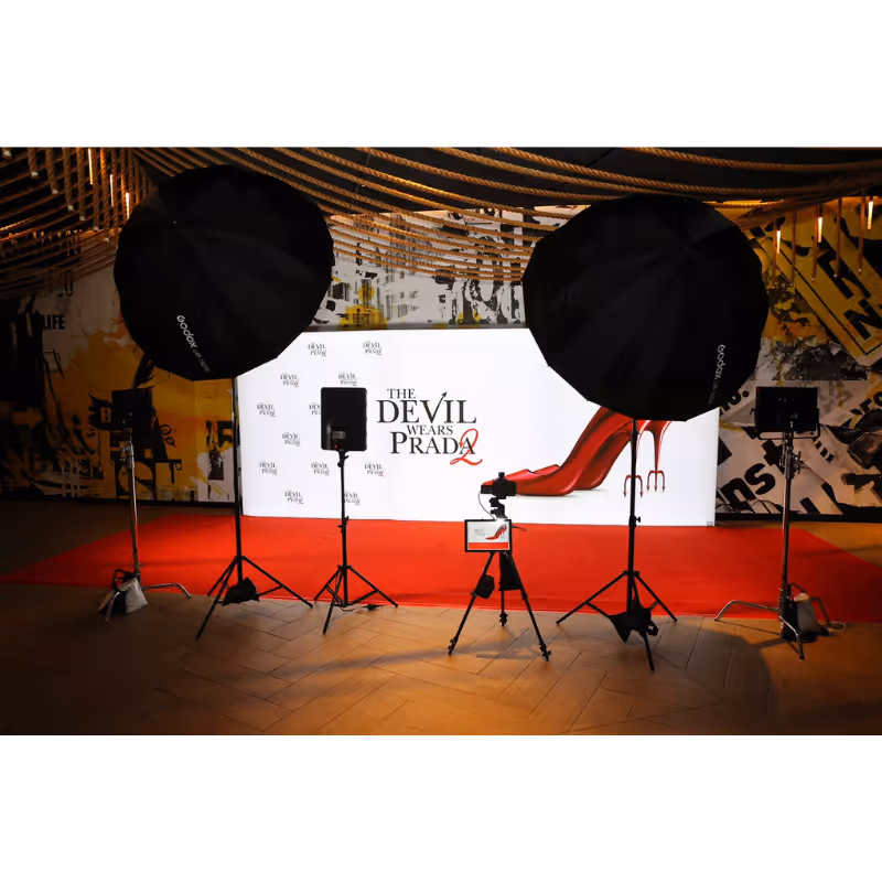 Photo setup with lighting and cameras facing a backdrop for The Devil Wears Prada 2 premiere.
