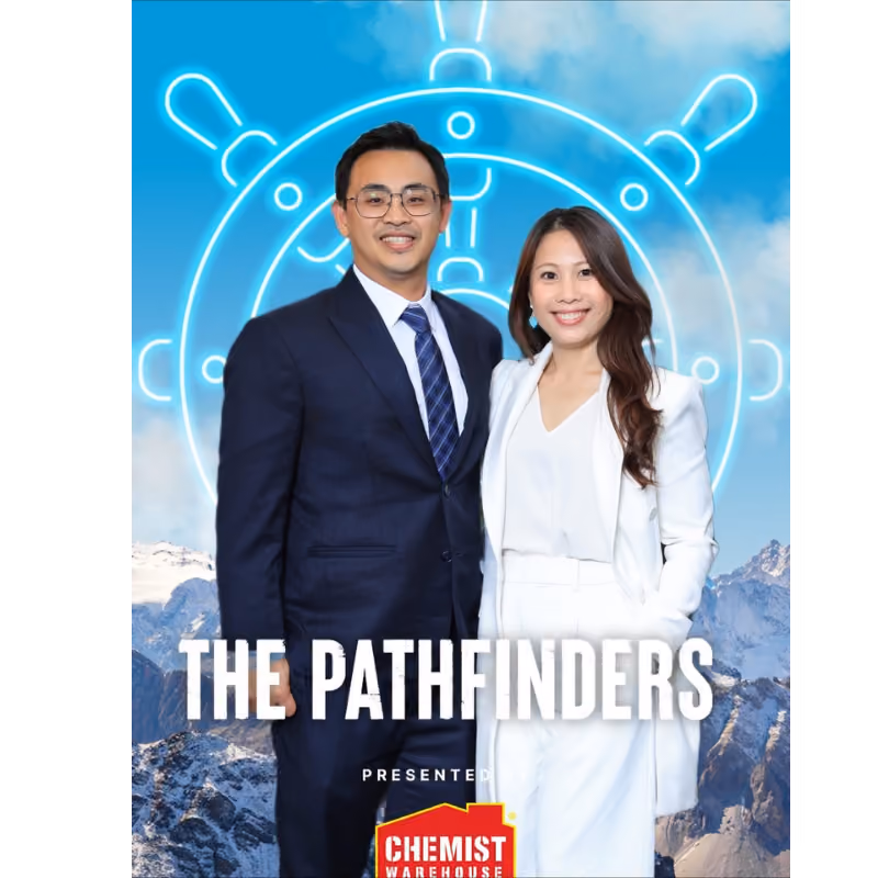 Man and woman in business attire smiling in front of a mountain and ship wheel background with text The Pathfinders.