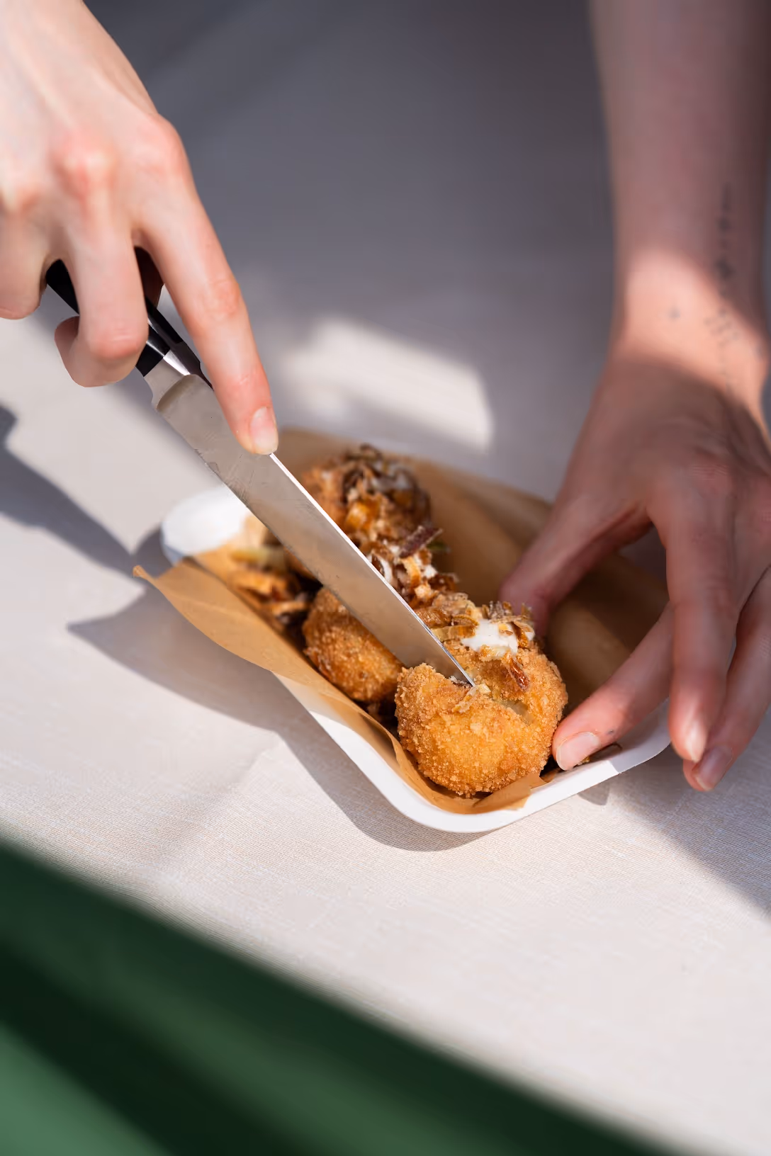 An arancini ball being sliced open with a knife