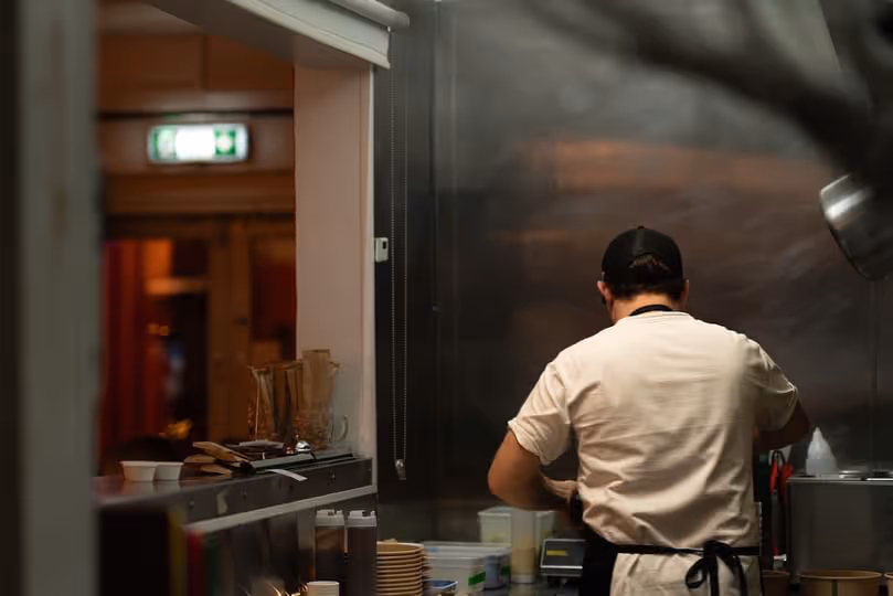 A chef working in at a stainless steel workspace
