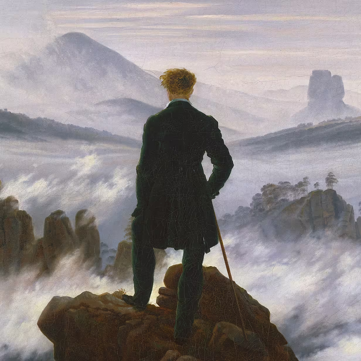 A painting by Caspar David Friedrich made in 1818 depicting a man in a dark coat standing on a rocky peak, gazing out over a foggy, mountainous landscape. The figure holds a walking stick and is seen from behind, framed by mist-covered ridges and distant peaks.