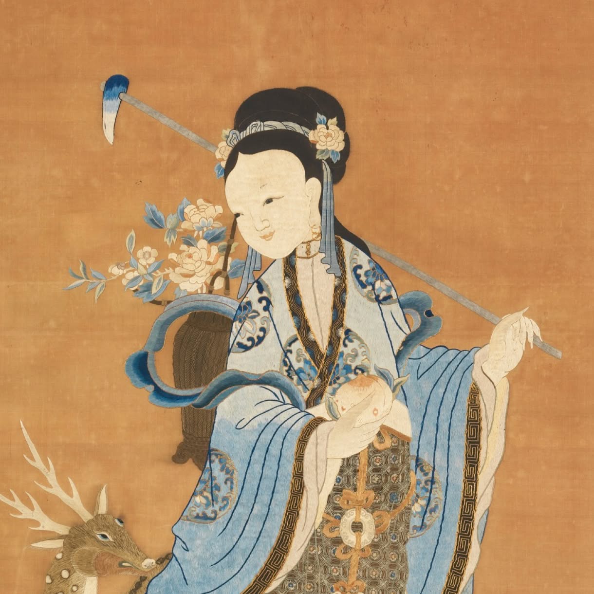 A traditional Chinese painting depicts an elegantly dressed woman in flowing blue-and-white robes seated beside flowering branches, holding a small animal in her lap while a deer appears at lower left.