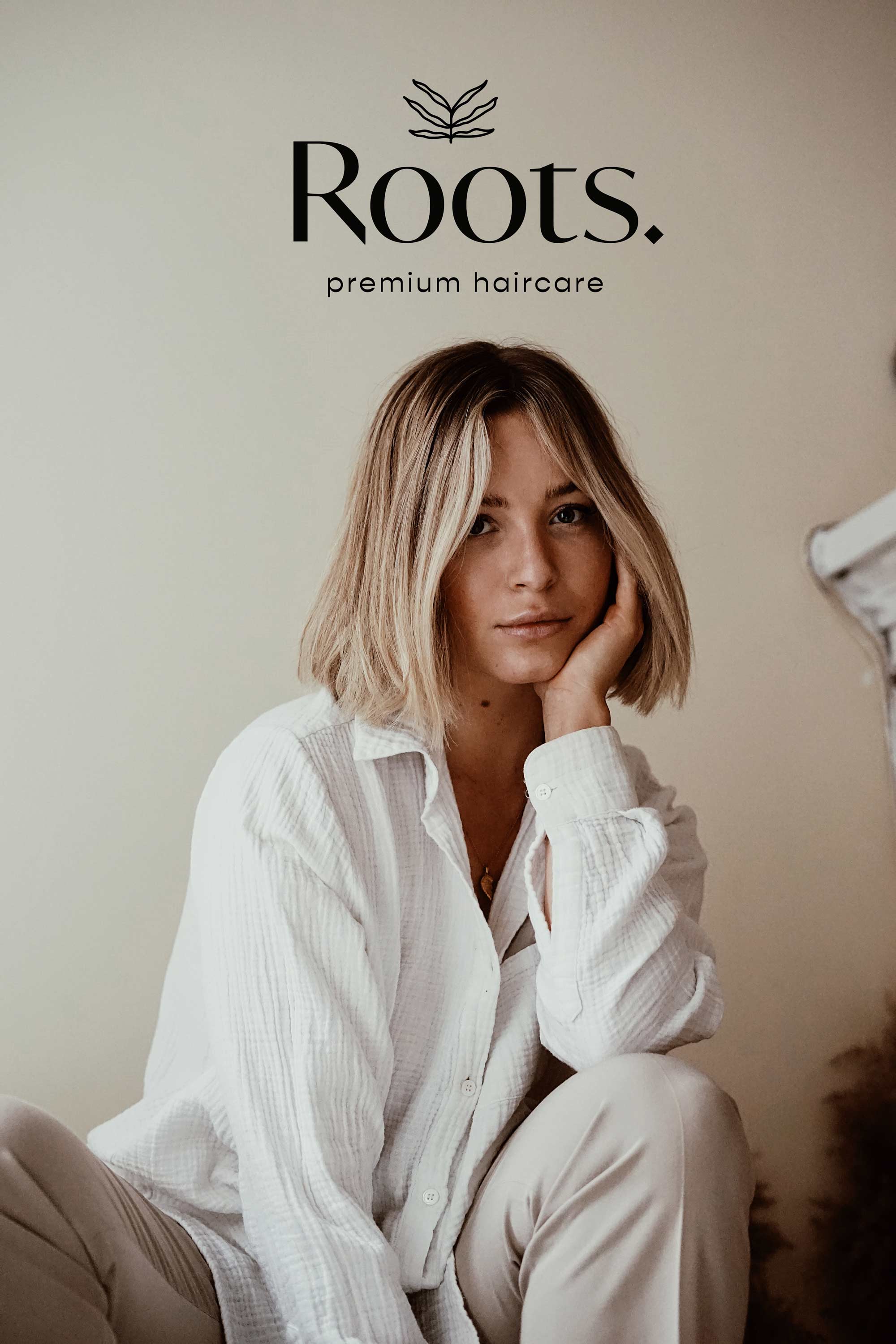 Roots primary logo placed ono a background with a women smiling