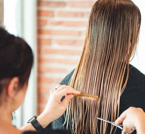 Une coiffeuse coupe des cheveux 