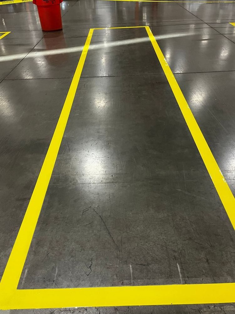 Finished yellow safety striping on warehouse floor — clean epoxy floor marking, PPD Painting project
