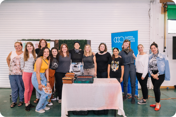 A group stands around a small table at a CCA event