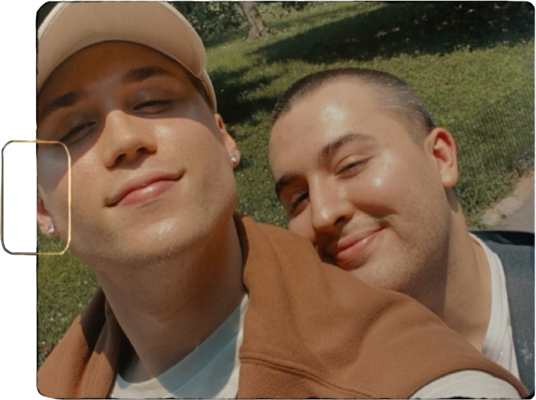Liam and Michael smiling for a selfie outdoors.