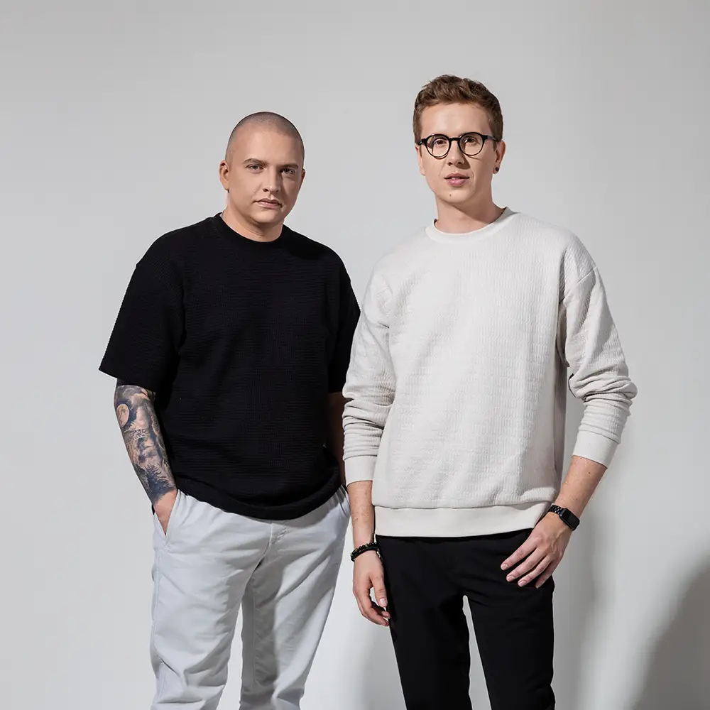 Założyciele studia, Karol i Przemek stoją na białym tle obok siebie.