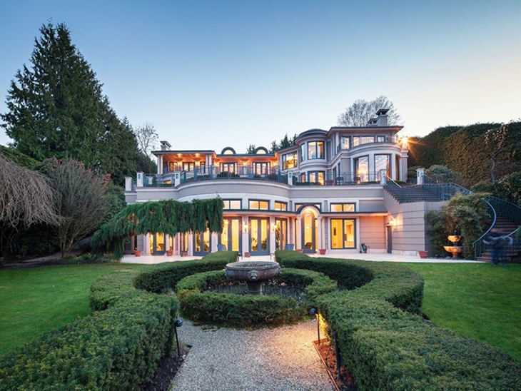 Happy family standing in front of their home in British Columbia, covered by reliable home insurance offered by InsureBC.