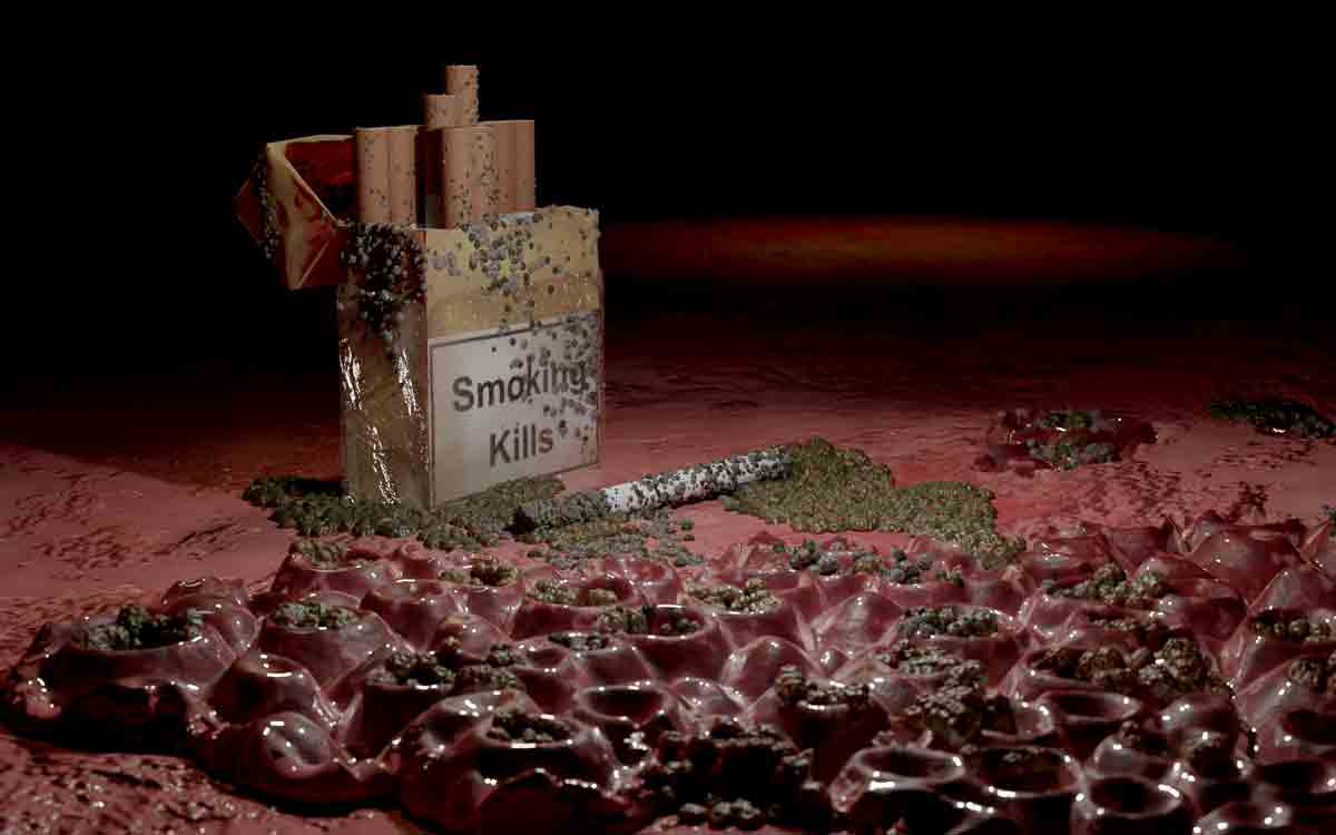 Open cigarette pack labeled 'Smoking Kills' with spilled tobacco and a cigarette lying on a textured red surface.