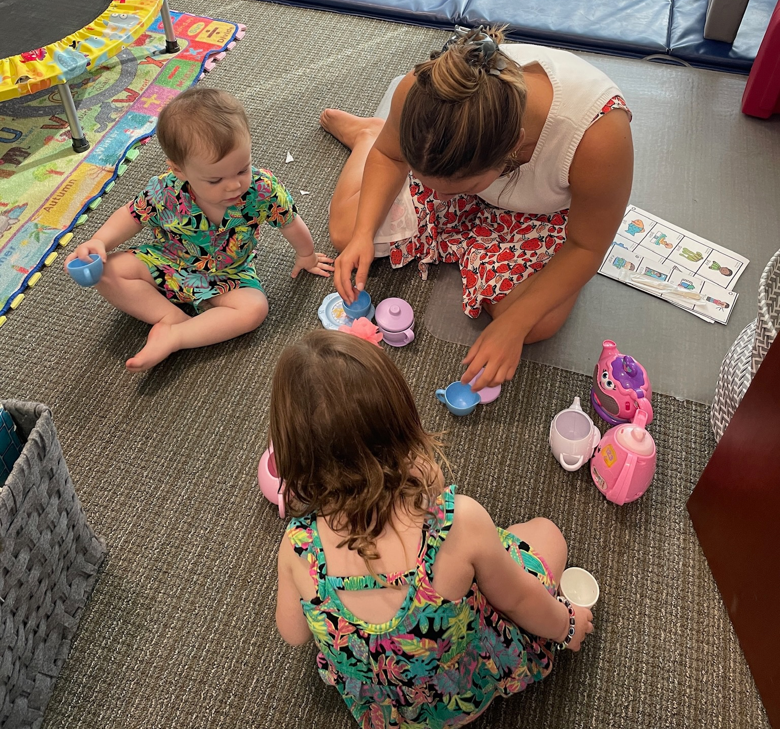 Speech-language pathologist playing a pretend tea party with two young children during a speech therapy session at Speech-N-Motion in San Marcos, California.