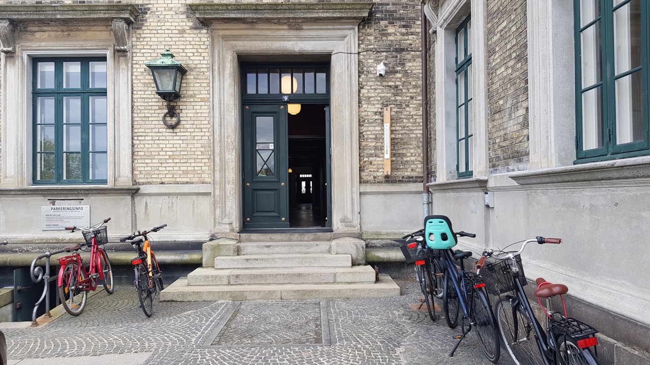 Indgang til by og havns hovedsæde, med skjult løfteplatform i belægningen foran trappen.