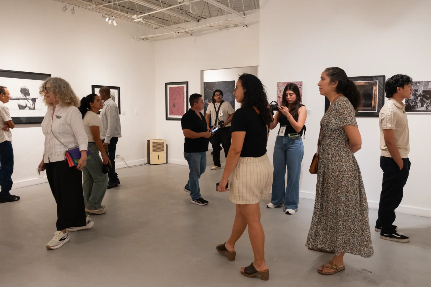 Visitors view paintings and sculptures in the exhibition