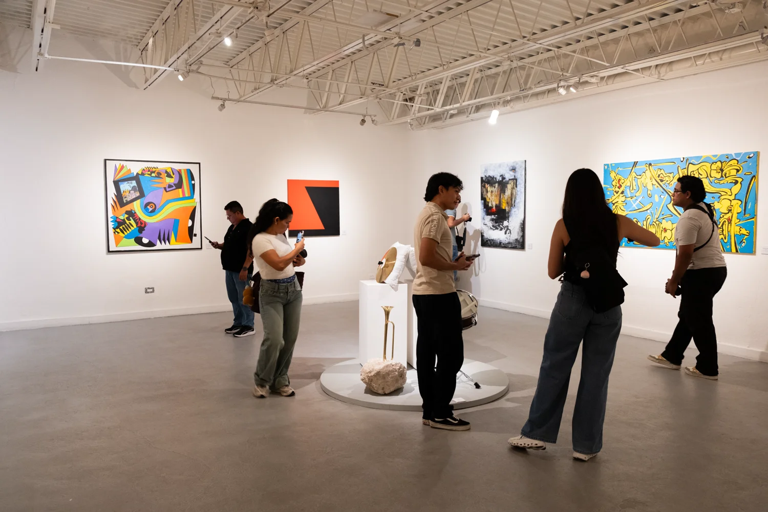 A visitor examines framed works in the gallery