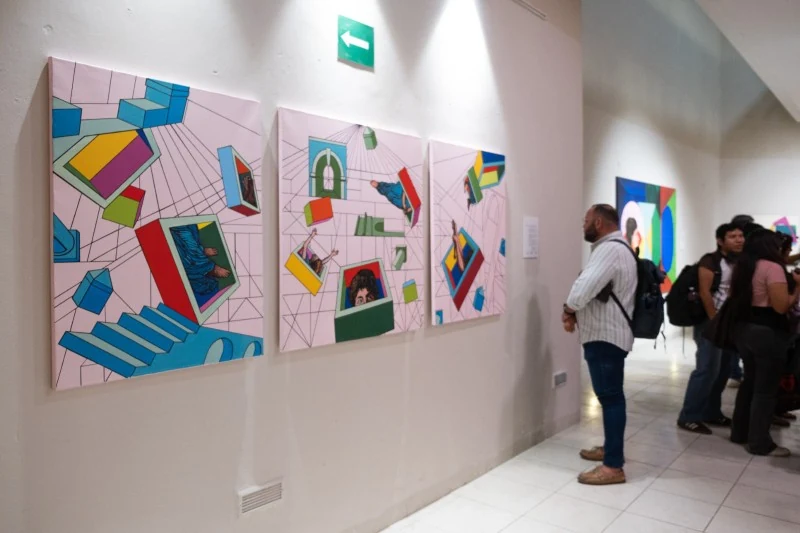 Visitors view paintings by Ivonne Ferrer in the UADY gallery