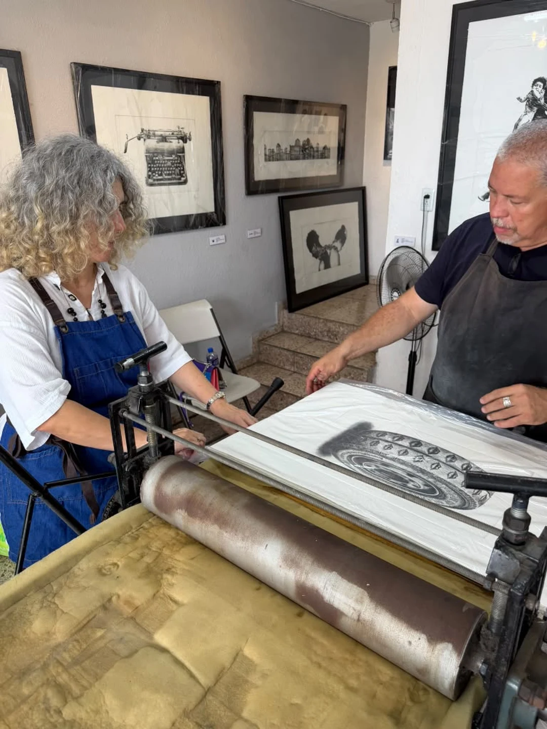 Ivonne Ferrer and a collaborator pulling a freshly printed engraving from the press at the Praxis Havana workshop.