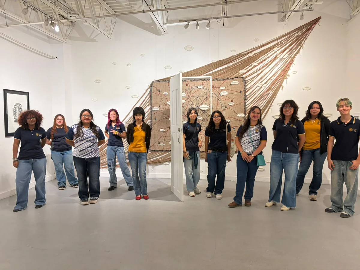Students viewing a large thread installation during the guided tour of «Colección MoCAA en Yucatán».
