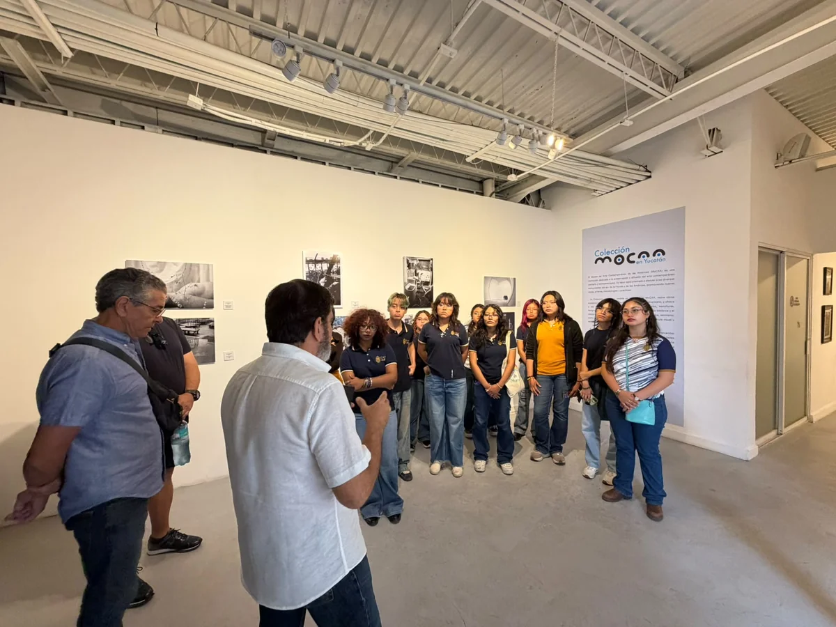 Art critic and curator David Mateo leading the guided tour in front of the exhibition wall text.