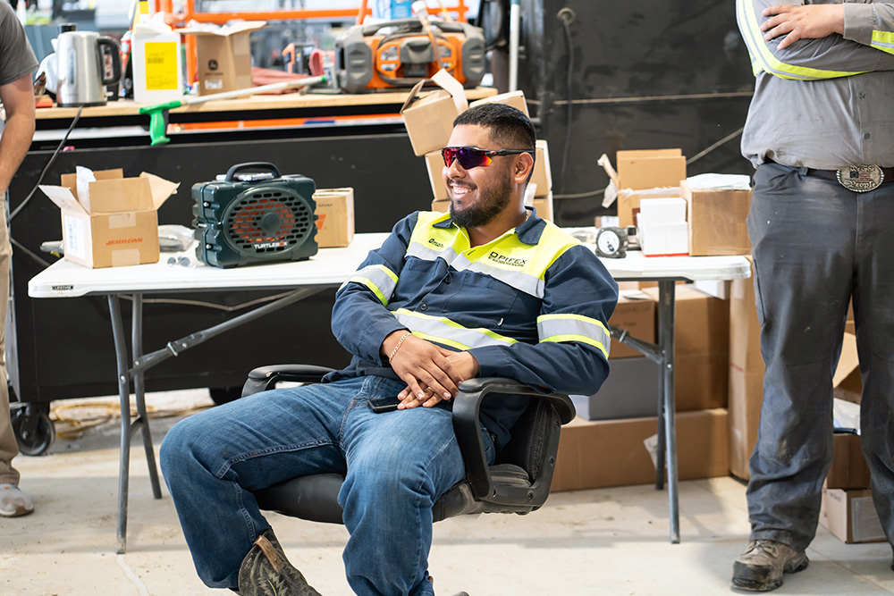 A worker is sitting at a table in our shop. He sure looks happy to be here!