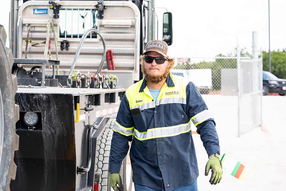 A worker walks beside a work truck