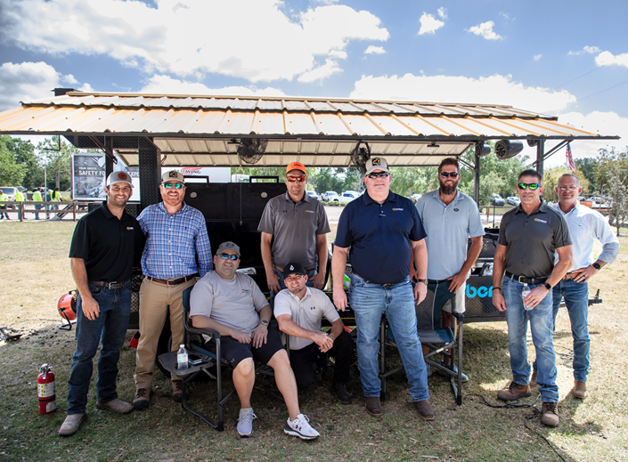 A few of our team members at an annual meeting, standing in front of our BBQ trailer.