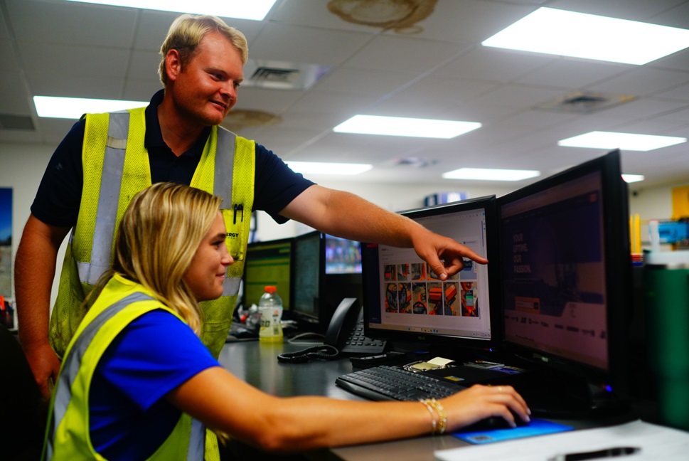 Two of our branch workers, one is guiding the other through a computer system