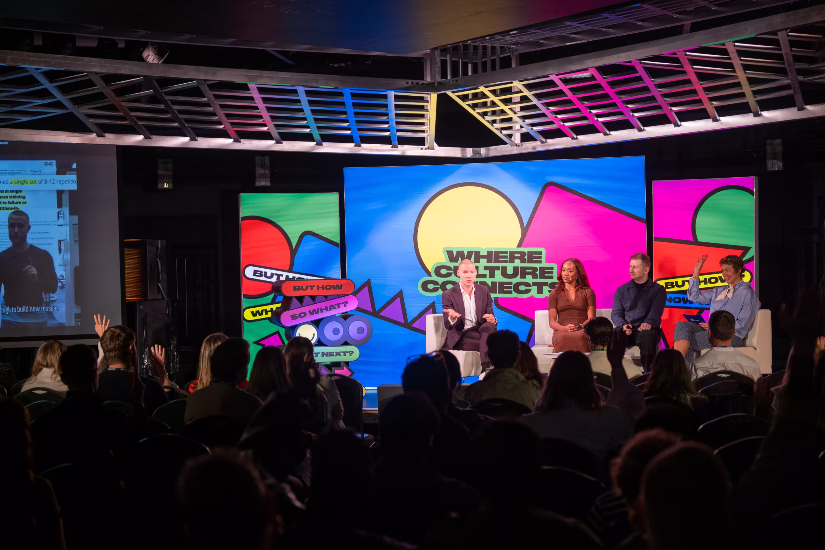 Four panellists in conversation on stage at Brands & Culture London 2026, seated in front of a bold, colourful LED backdrop reading "Where Culture Connects", with a full audience watching from the darkened venue floor.