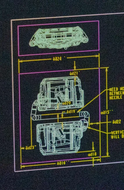 Image of design engineer sitting in front of computer designing mold components. 