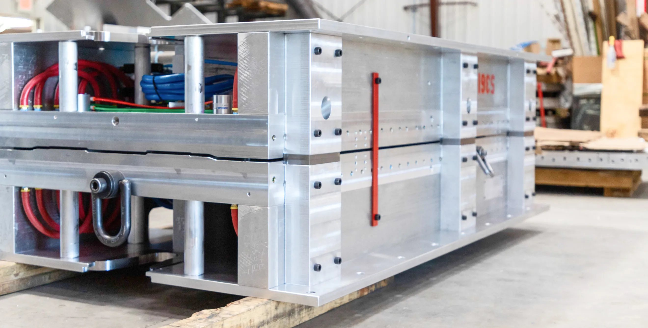 A completed aluminum blow mold sitting on pallet. 