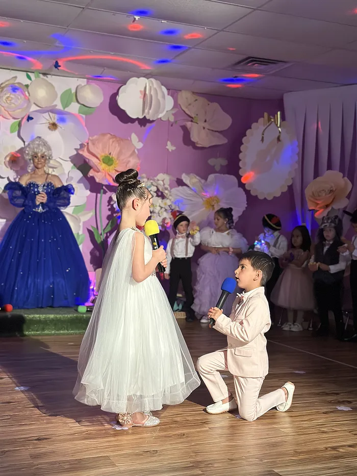 Children performing in colorful costumes at Children’s Land preschool music and drama event.