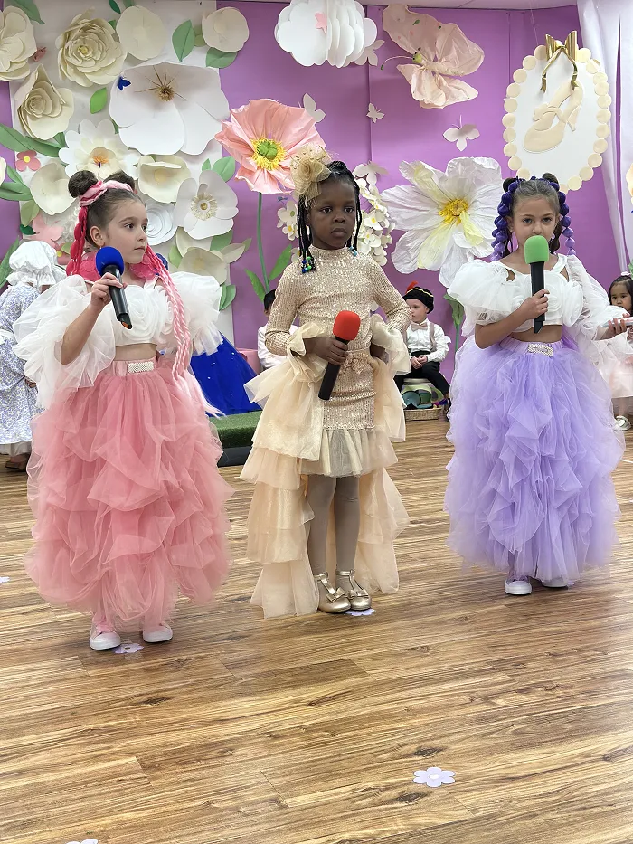 Preschool children in ball gowns and costumes performing at Children’s Land Broadway program.
