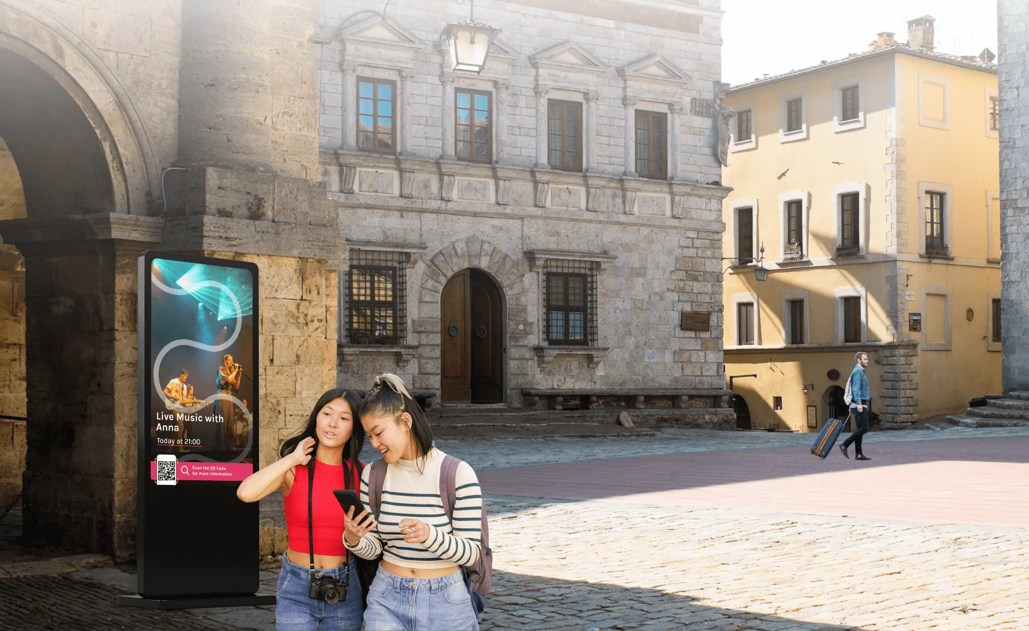 Due turiste consultano informazioni accanto a un totem digitale in una piazza storica