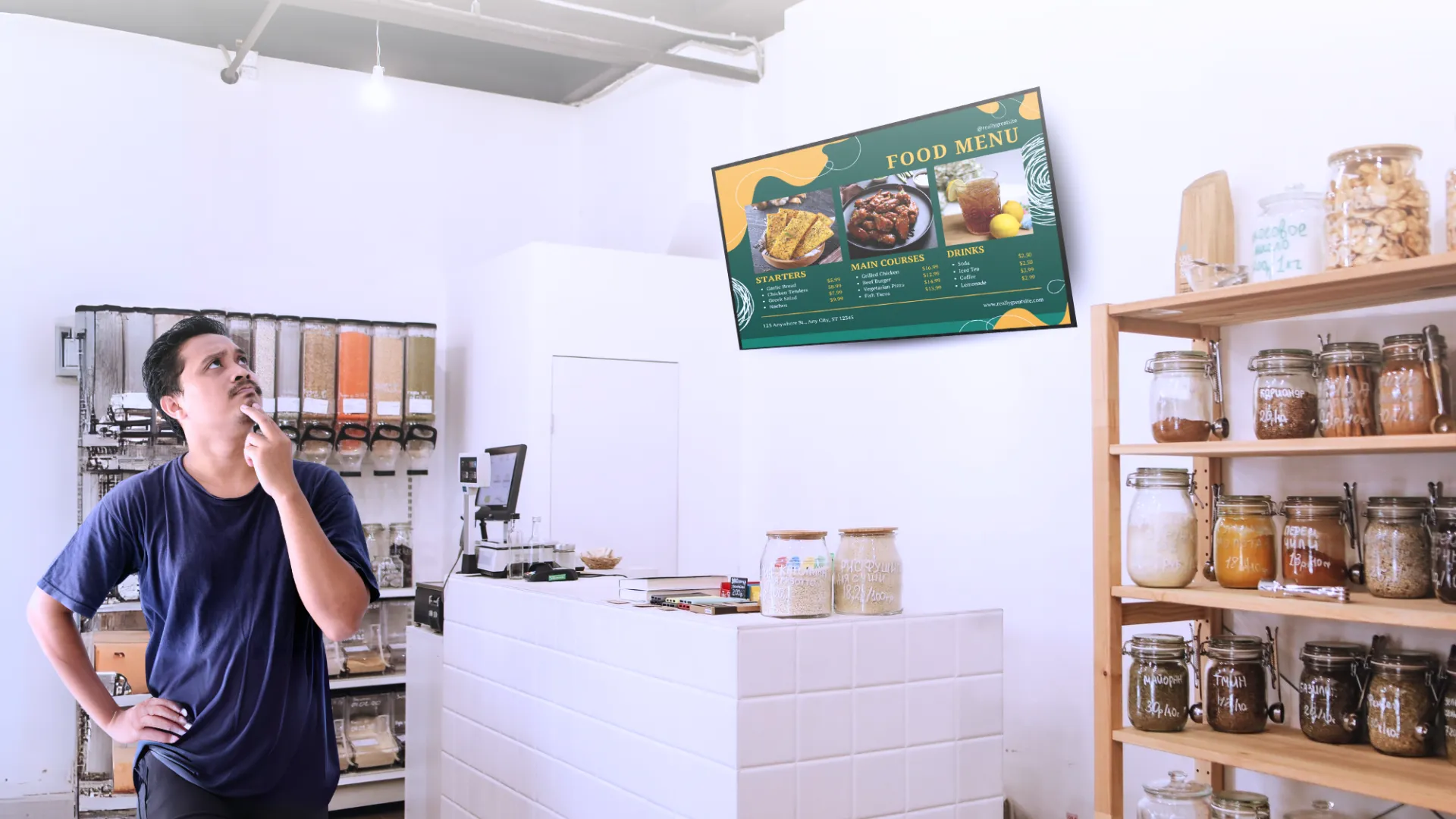 Addetto di un locale osserva un display digital signage con il menu aggiornato