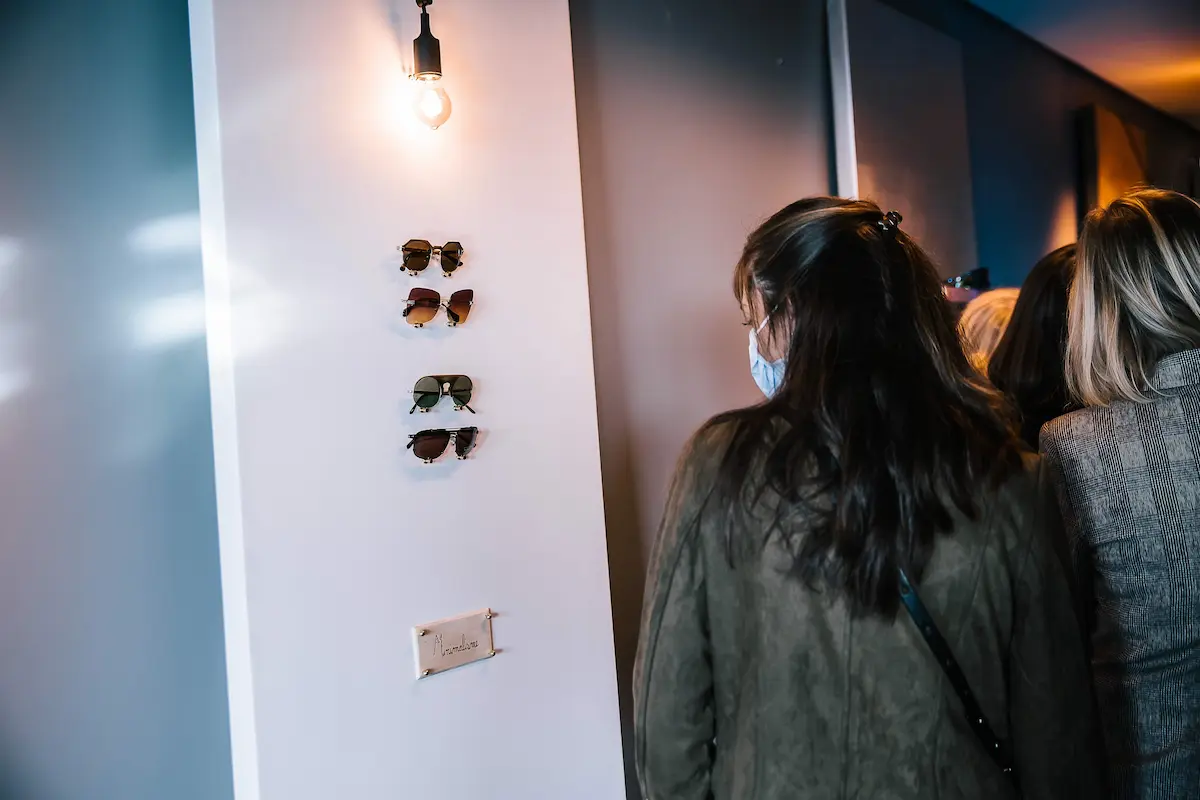 Invités explorant l'espace tendance avec des lunettes Luxottica lors des journées presse FW21 à Paris.