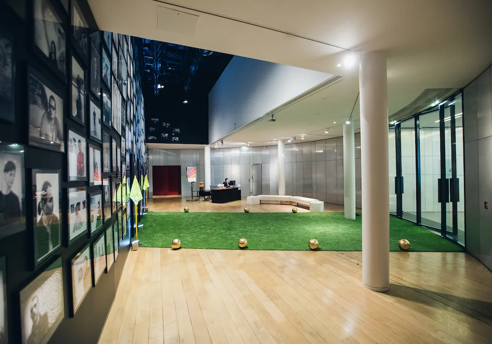 Photo du lancement de la collection Louis Vuitton x FIFA 2018, montrant des ballons dorés et des décorations festives