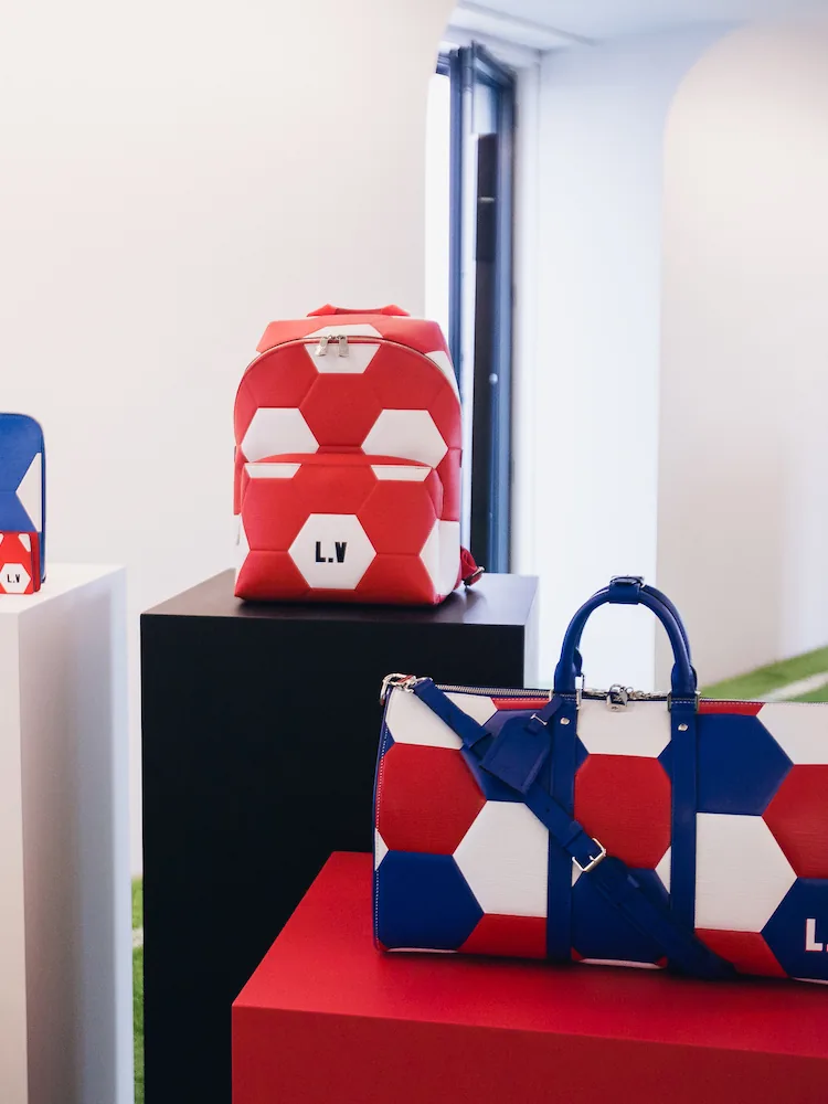 Photo du lancement de la collection Louis Vuitton x FIFA 2018, montrant des ballons dorés et des décorations festives