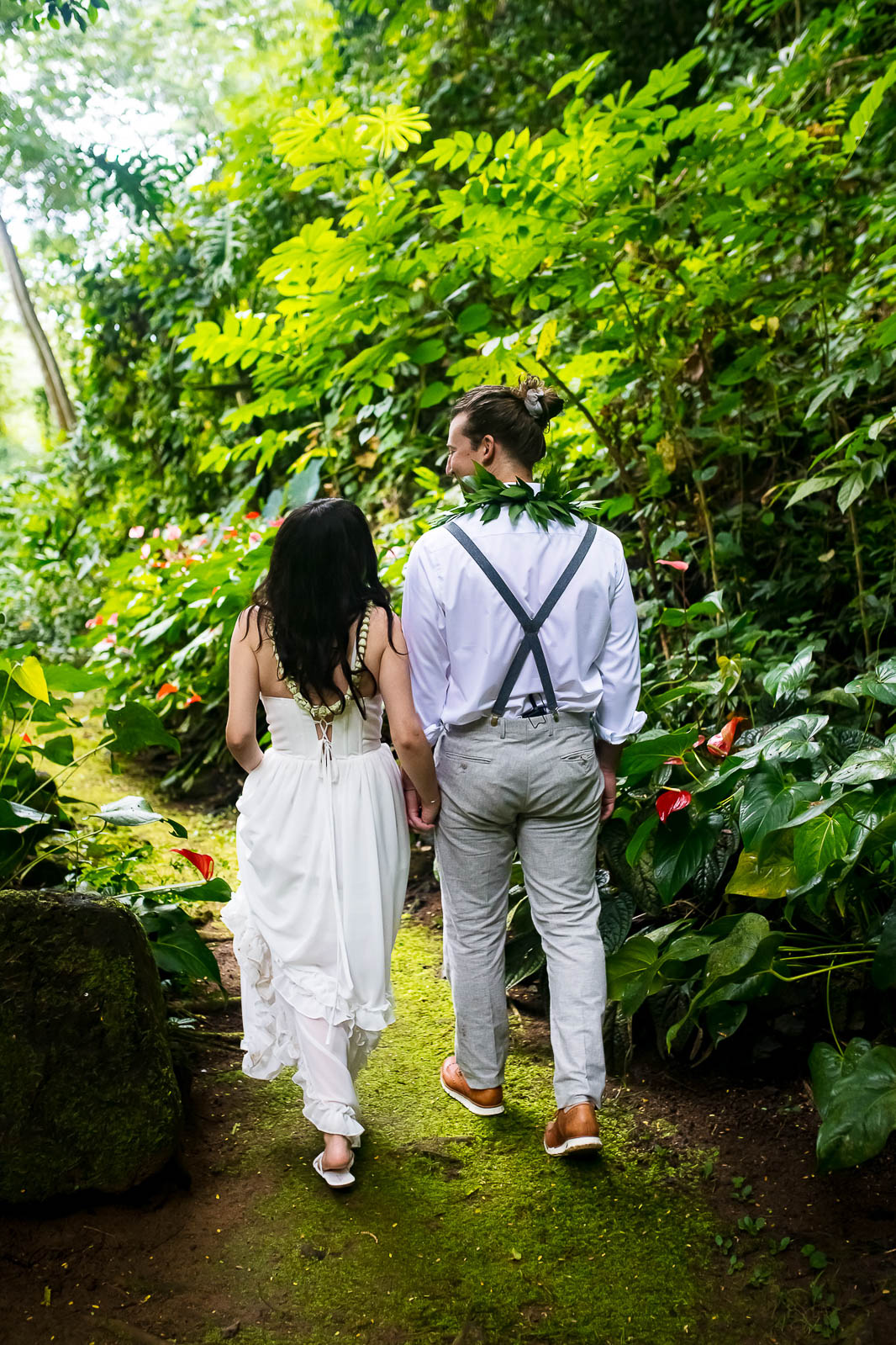 Newlywed couple walking off into Kauai jungle 