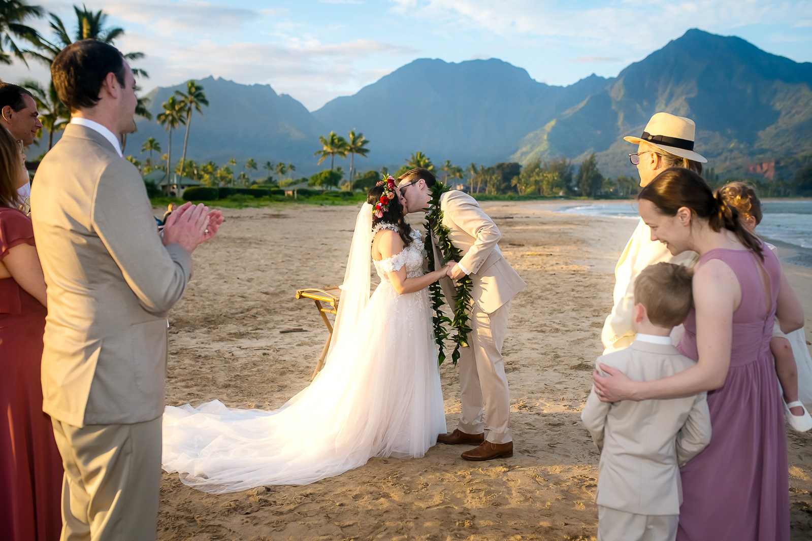 Bride and groom share first kiss as guests cheer.