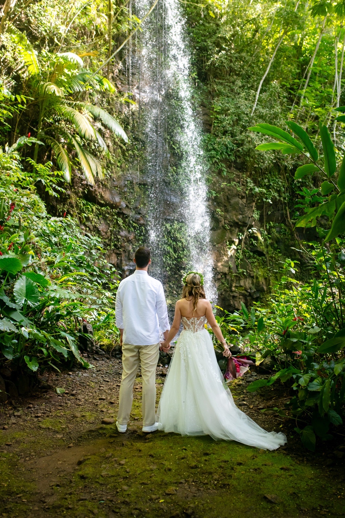 couple looking at waterfall during kauai wedding