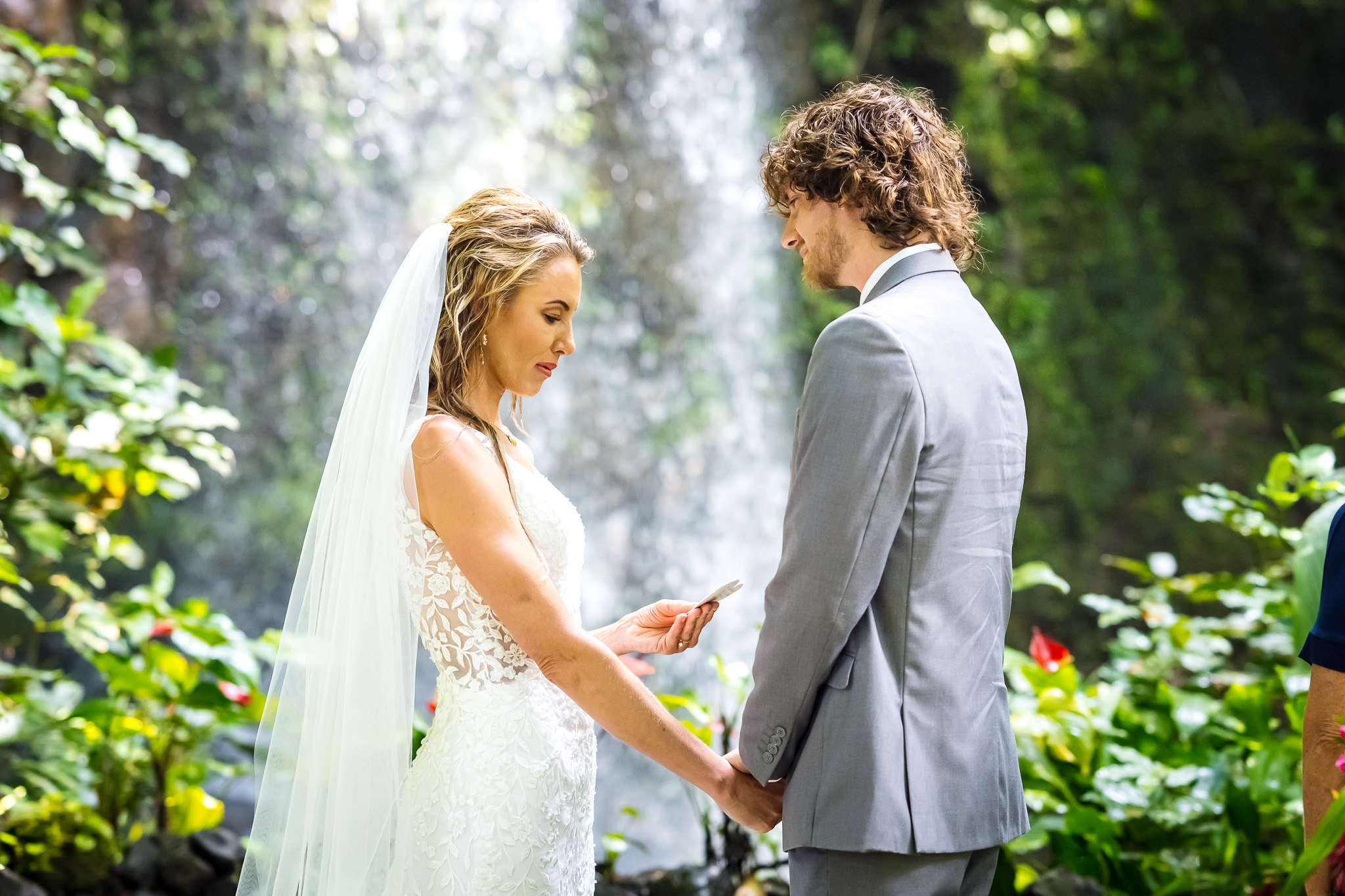 couple reading vows in front of waterfall at elopement on kauai