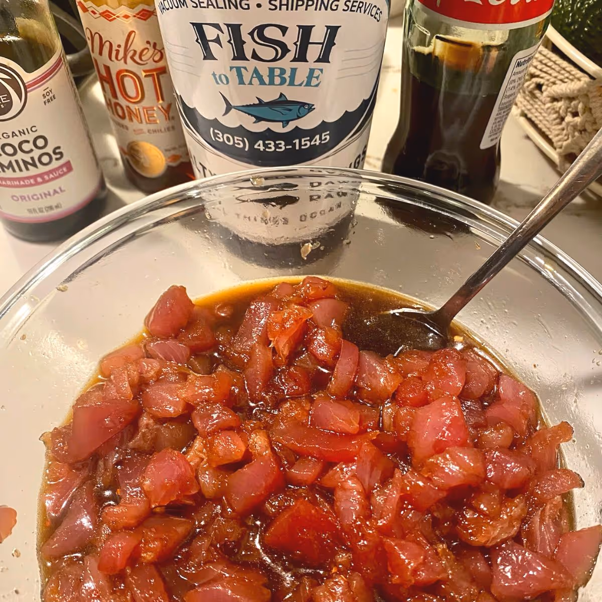 Tuna poke in a bowl with a Fish to Table sticker in the background.