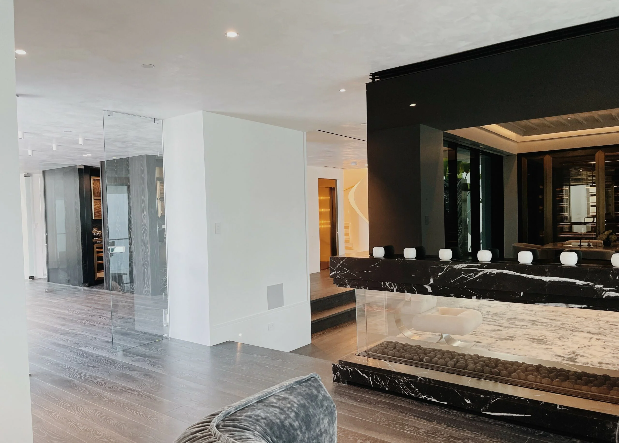 Bespoke home elevator finished in Bronze stainless steel serving the bar area of a high-end residence