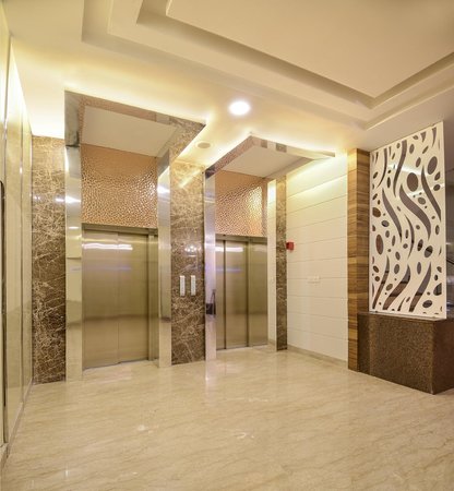 Bespoke DDA access step lift providing wheelchair access between levels in a public building. The step lift has steel painted framework with glass side panels and gate