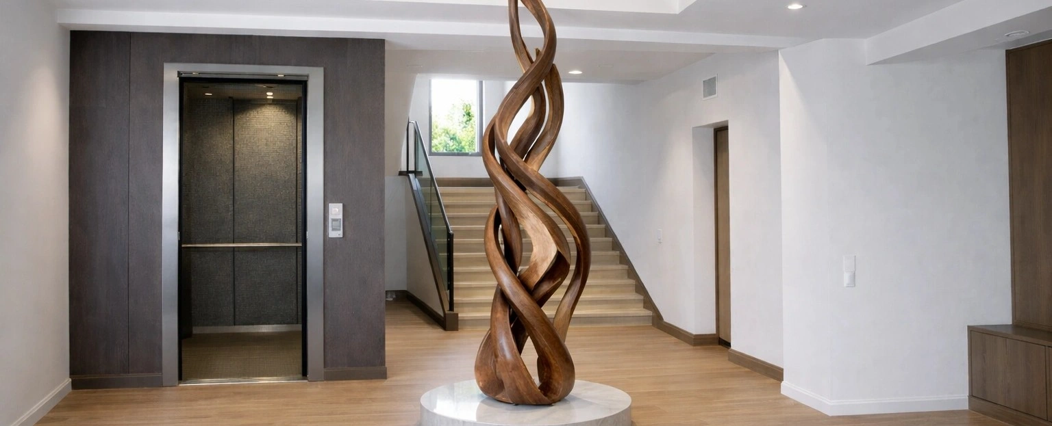 Matt black painted home lift installed at the far end of a white marble kitchen