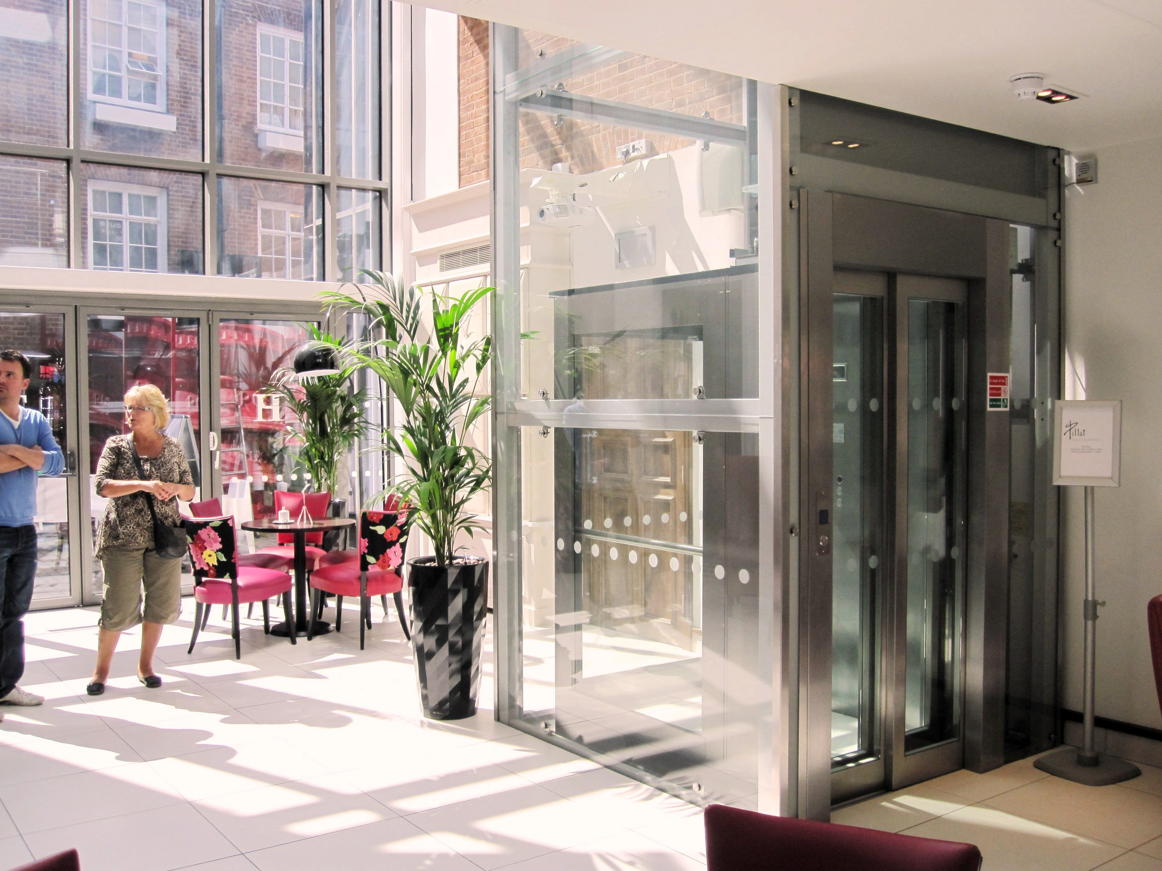 Commercial lift with mirrored stainless steel telescopic landing doors