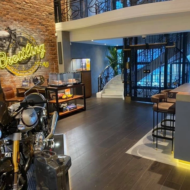 Step lift sited in a rustic brick lift shaft. The wheelchair access lift is finished with fully glazed side panels and black painted steel