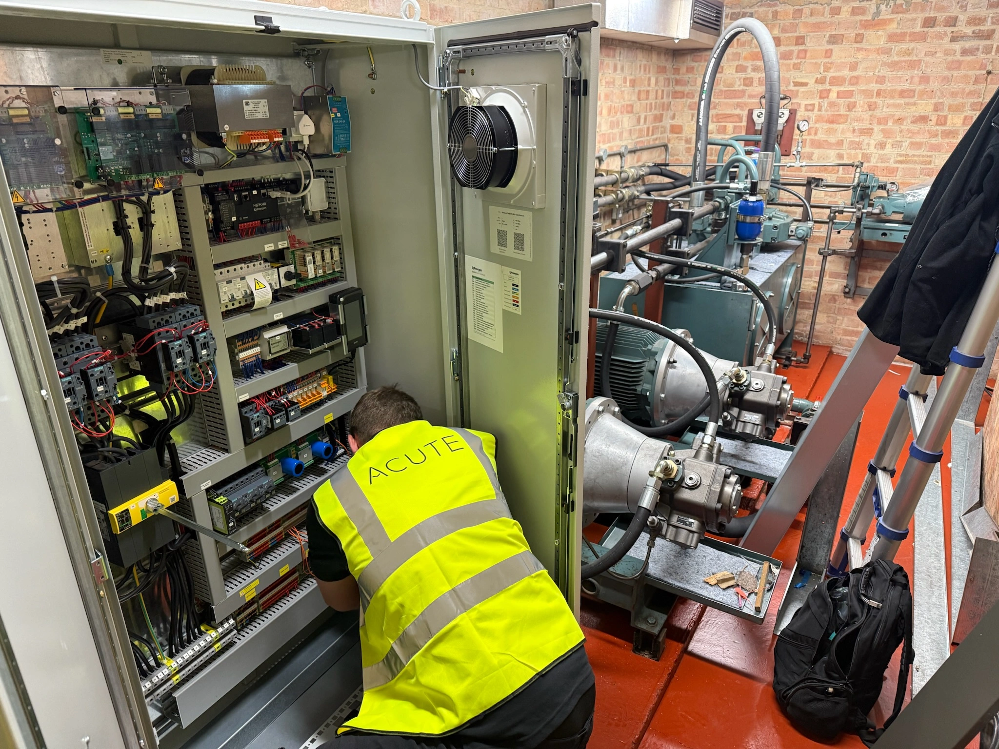 Lift servicing engineer inspecting control panel and components 