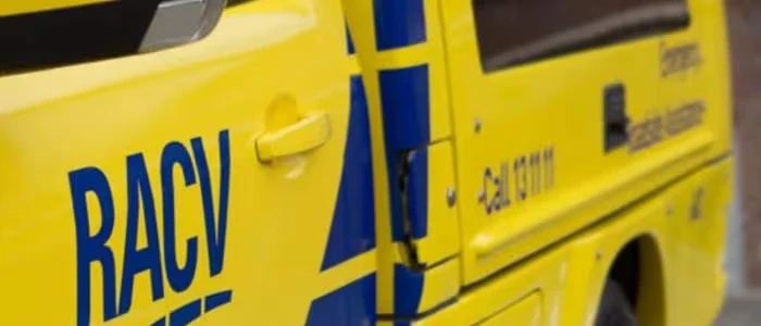 A yellow RACV roadside assistance vehicle is parked on the street.