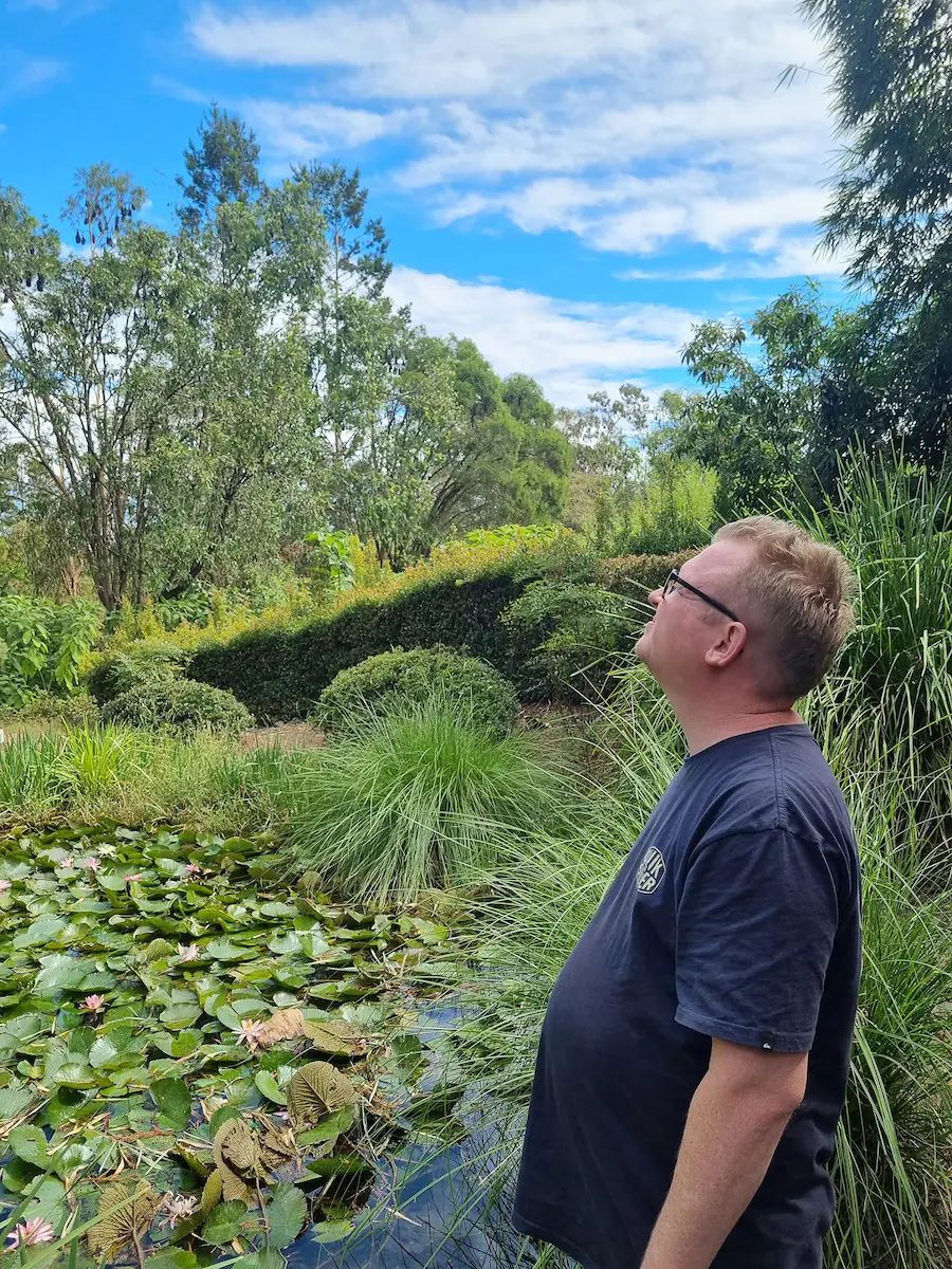 Man gazing out across a lush park surrounding