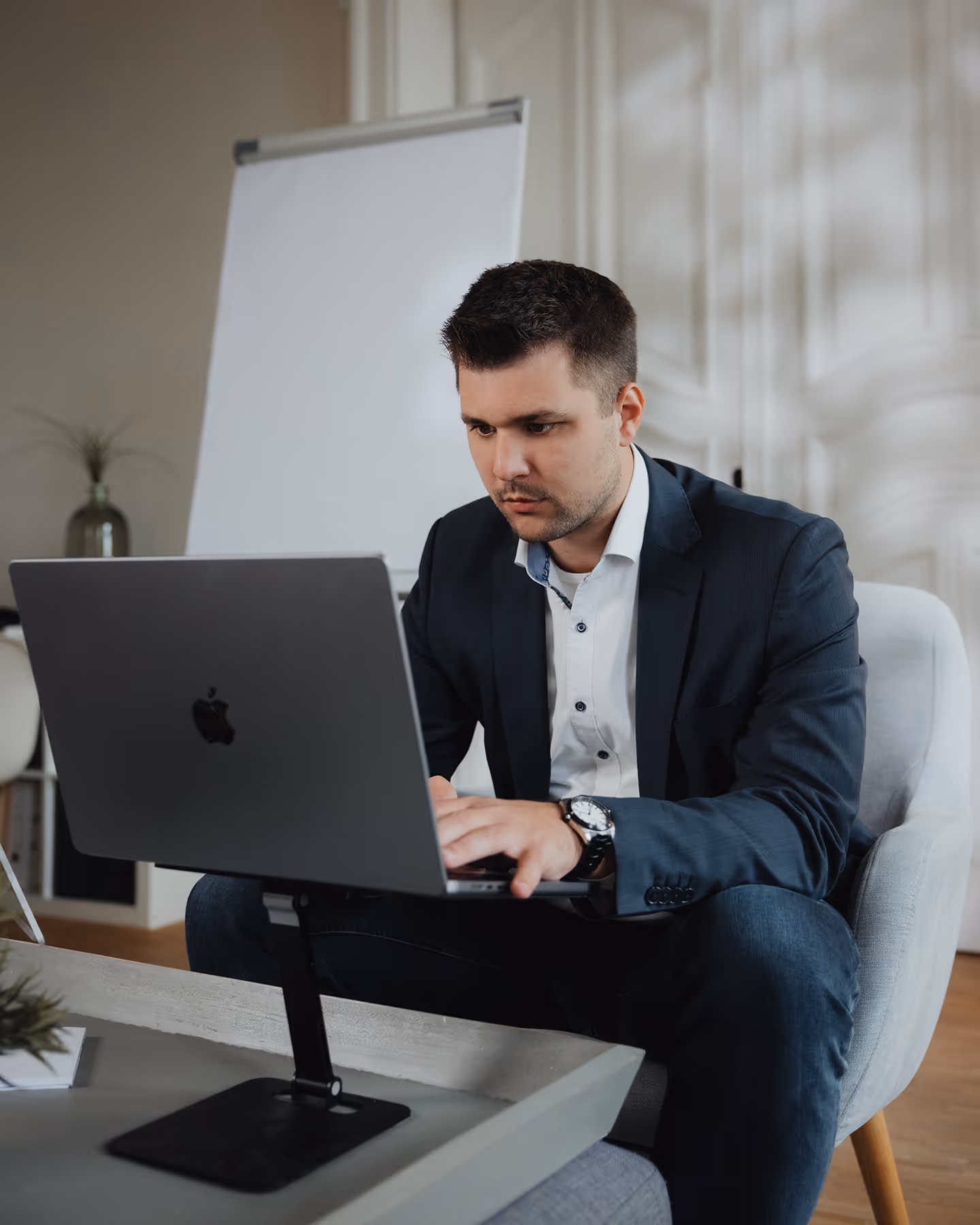 Marcel Speckmann erarbeitet eine SEO - Kampagne an seinem Macbook und schaut dabei konzentriert.